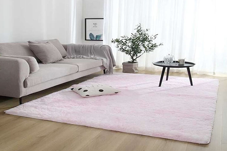pink rug with a grey couch
